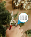 Hand using scissors with inset image showing 'Stainless Steel Compression Springs Assortment Kit With 240 Pieces In 15 Different Sizes'