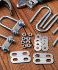 Durable stainless steel U bolts kit with 6 bolts, plate, 12 nuts and washers laid out on wooden surface