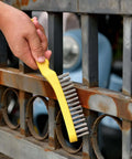 Wire Scratch Brush 2 Set in use, cleaning rust from metal railing; heavy duty stainless steel 11 inch with plastic handle by MAXMAN.