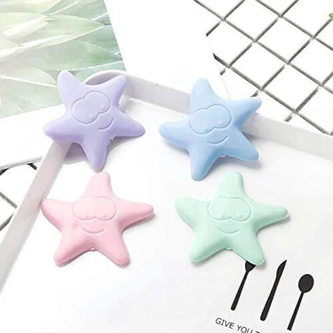 Four starfish-shaped bumpers in purple, blue, pink, and green, Self-Adhesive Silicone Door Handle Bumpers Protect Walls, Absorb Shocks, And Quiet Door Impacts With No Tools Required, Delivering Durable, Universal Wall Protection For Any Door, Knob, Or Handle Area, on a white surface.