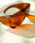 Amber StarShield Fit Over Sunglasses With Lenses And Blue Light Blocking UV Protection on table