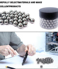 Person using steel balls in assembly with container of small metal balls, showcasing craftsmanship and precision materials.