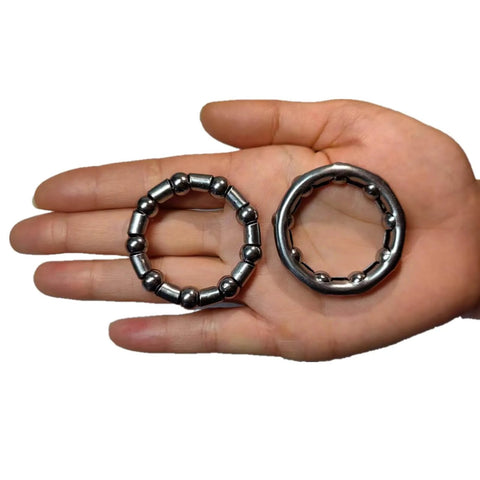 Hand holding Bike Ball Bearing Retainer Set 5/16 Inch Ball Bearings for Bicycle Crank Bottom Bracket Replacement, showing two retainers.