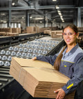 Worker handling cardboard next to 16 Pcs Table Ball Slide Units Roller Ball Transfer Bearings with 1 Inch Carbon Steel Ball for conveyors.