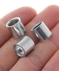 Close-up of three steel spacers from the 4-Pack Skateboard Steel Spacers Kit resting in a hand.