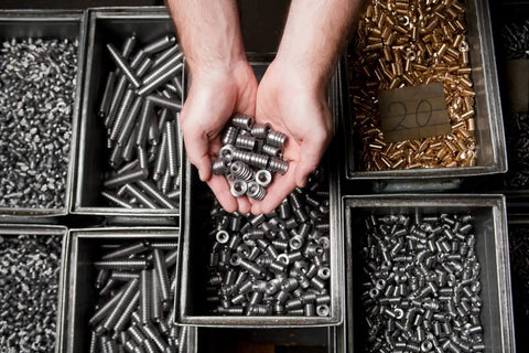 Person holding multiple heavy duty threaded steel wood inserts with hex drive and sealing collar, 1/4-20 internal thread, compatible with all wood substrates.
