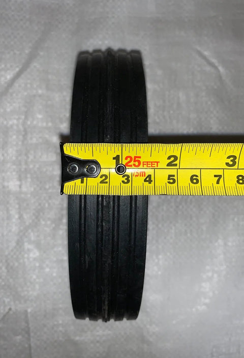 Close-up of 7 Inch By 1.5 Inch Steel Ball Bearing Wheel For Power Trim Edger Replacement OEM Part 332 with tape measure