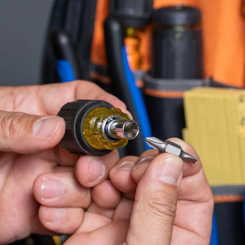 Hands holding 6-In-1 Stubby Screwdriver And Nut Driver With Interchangeable Shaft And 4 Universal Tips, showing bit attachment.