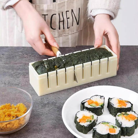 Person slicing sushi with Complete Sushi Making Kit With 3 Shape Molds Rice Roller Tool And Spatula For Pro Looking Home Rolls