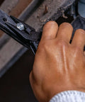 Hand using Suspension-NXT 15-In-1 EDC Multi Tool with needle nose pliers on metal structure