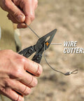 Hands using the Suspension-NXT 15-In-1 EDC Multi Tool with pocket knife, needle nose pliers and wire stripper outdoors.