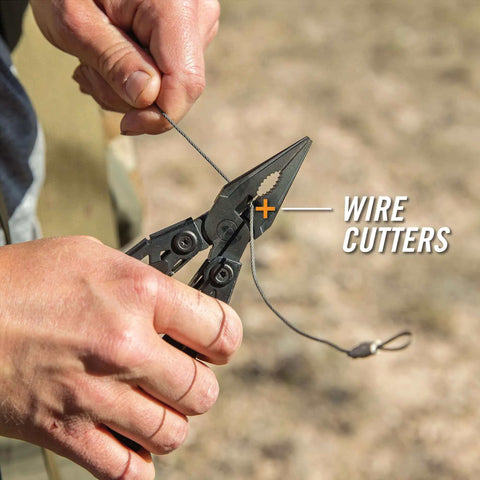 Hands using the Suspension-NXT 15-In-1 EDC Multi Tool with pocket knife, needle nose pliers and wire stripper outdoors.