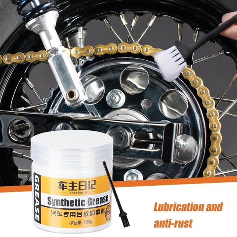 Synthetic grease jar with brush near vehicle chain suggesting use for lubrication and anti-rust protection