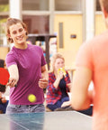 Person playing ping pong with colorful table tennis ball, highlighting use for 100 Pack Table Tennis Balls,40mm Colored Plastic Balls Beer Balls Bulk.