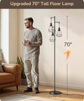 70 Inch Farmhouse Floor Lamp With Diamond Cage Shade And Dimmable Lighting Includes Three LED Edison Bulbs Rustic Tree Corner Accent For Living Room Bedroom Or Office Black Finish Modern Cozy Vibe Lighting next to a man holding a cup.