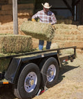 OneStep Wheel Chock Double Pack For Tandem Axle Trailers And RVs, 16 To 24 Inch Long under a loaded hay trailer
