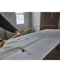 Person using Atomic Compact 30 Ft Tape Measure With Finger Brake For Precision And One Hand Quick Measurement on a workbench