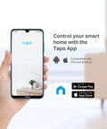 Hand holding smartphone displaying Tapo app for smart home control, compatible with iOS and Android, with app store icons visible.