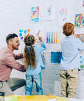 Teacher helping children hang art with Teacher Tape Pads Double Sided Removable Foam Tape For Wall Mounting 96 Pieces Per Pack