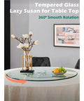 22.8 inch tempered glass lazy susan rotating serving tray on a dining table with flowers and fruits for easy serving.