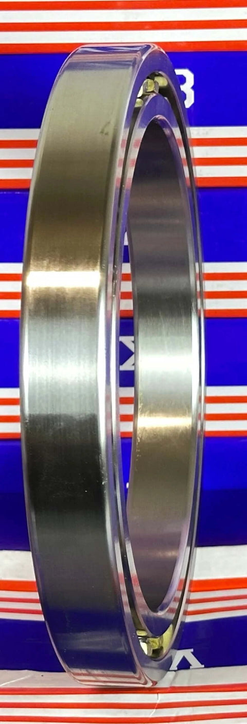 VG065CP0 Thin Section Bearing 6-1/2" x 8-1/2" x 1 inch chrome steel ring side view against a striped background.