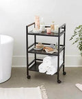 Three Tier Metal Rolling Utility Cart With Open Shelves For Quick Access And Grab And Go Mobility Ideal For Kitchen Bathroom And Workshop Durable Metal Construction In Black From Amazon Basics shown in bathroom setup.