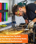 4 Slot TIG Welding Rod Holder Storage Rack on workshop wall with colorful rods, welder using grinder nearby
