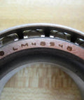 Close-up of TIMKEN LM48548 Tapered Roller Bearing with visible engraved model number and exposed rollers.