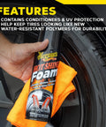 Hand holding Hot Shine Tire Foam High Gloss Tire Shine That Cleans Shines And Protects In One Easy Spray Step For Deep Black Tire Finish With Conditioning Oils And UV Protection Stays Put Then Dissolves Clear Aerosol 19 Oz against a tire with an orange cloth.