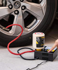 ResQ Tire Repair Kit With 12V Air Compressor And Cigarette Lighter Plug in use by a car, with sealant attached to a tire
