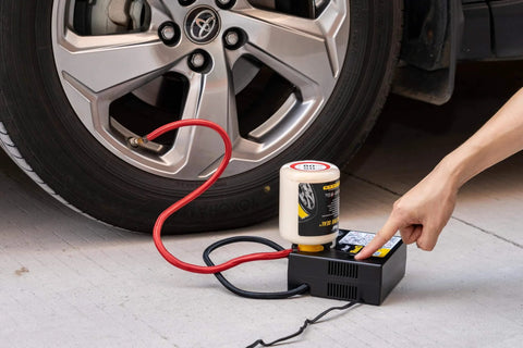 ResQ Tire Repair Kit With 12V Air Compressor And Cigarette Lighter Plug in use by a car, with sealant attached to a tire
