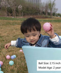 Toddler playing with Ball Pit Balls for Toddlers, BPA Free Crush Proof Plastic Toy Balls for Ball Pit in a blue tub outdoors.