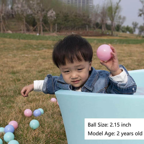 Toddler playing with Ball Pit Balls for Toddlers, BPA Free Crush Proof Plastic Toy Balls for Ball Pit in a blue tub outdoors.