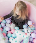 Toddler playing in a ball pit with pastel-colored balls, featuring 200 Count Plastic Soft Plastic Ball Pits Balls Colorful Play Pits Balls for Pet Dogs Ball Pits 2.2" Large Phthalate Free Bpa Free Balls for Toddlers 1-3 Baby Kids.