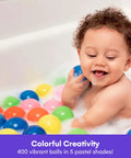 Young child playing with colorful plastic ball pit balls in bathtub, smiling. Ball Pit Balls for Kids, 200 Pack - Plastic Refill Balls.