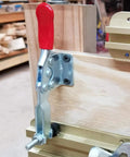 Installed Heavy Duty 12 Pack 201B Toggle Clamp For Woodworking, galvanized iron, red antislip handle, securing wooden piece.