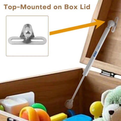 Two Pack Soft Close Toy Box Hinges With 150N Gas Strut for heavy curved lids installed on box, showing hinge and wooden box with toys.