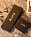 Black gift boxes displaying brand name Tornito, suitable for jewelry packaging, on a textured surface with decorative elements.