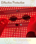 Hands holding transparent safety goggles under red light, emphasizing eye protection against bright lights.