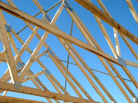 Wooden roof trusses with Truss Spacer Restraint Kit For Quick Accurate Spacing During Sheathing Pro Grade Galvanized 22 Gauge Steel 25 1 2 Inch TSBR2 24 Easy Installation Spacers Stay In Place Pack Of 50 in place against a blue sky.