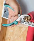 Using pliers from the 104 Piece Home Repair Tool Set with Easy Carrying Pouch for DIY Projects and Everyday Fixes in turquoise pouch.
