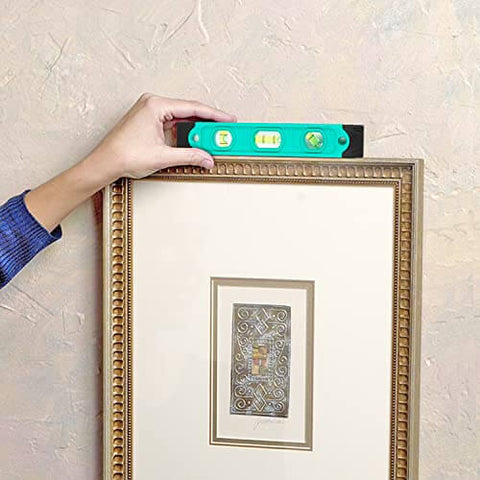 Adjusting picture frame with level from 104 Piece Home Repair Tool Set With Easy Carrying Pouch For DIY Projects And Everyday Fixes