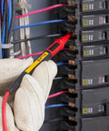Hand using Twistguard Test Leads, 2 mm Diameter Probe Tips to test electrical panel connections, highlighting flexible use and design.