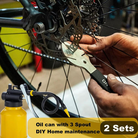 Two Pack Metal Yellow Pump Oil Can With Three Spouts For Precise Lubrication In Tight Gaps shown in use on bicycle maintenance