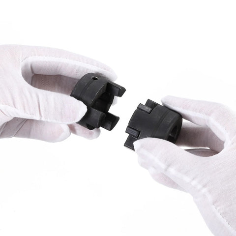 Two L-jaw coupling halves in black plastic with Buna-N rubber spider, held by gloved hands