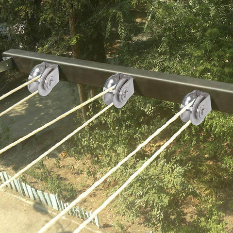 U Groove Pulley Block 2", 304 Stainless Steel Pulley Roller installed on metal beam for wire rope traction, outdoor view