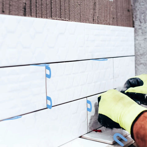 Close-up of 800 Pack U Shaped Tile Spacers for leveling and tile alignment in blue, used in DIY home renovation.