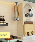 Kitchen showing 2 Pcs Under Cabinet Metal Utensil Hanger with 6 Rotatable Claws, top mounted near cutting boards and jars on a countertop.