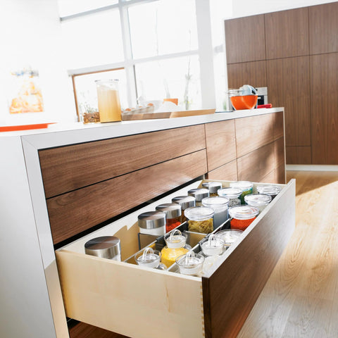 Open kitchen drawer with Blum Tandem Plus Blumotion Concealed Undermount Drawer Runner Kit for wood drawers, filled with jars.