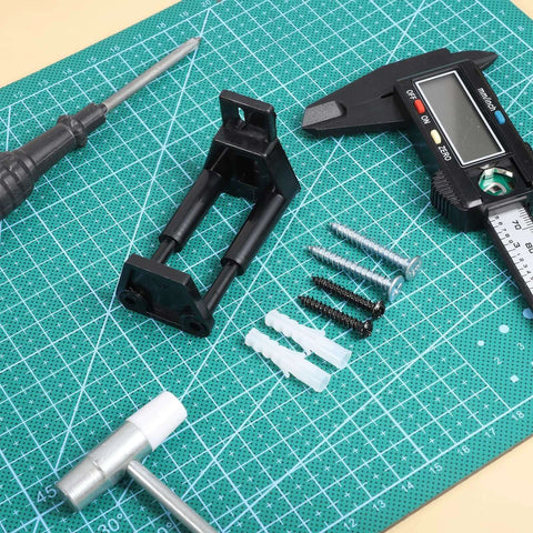 Universal Adjustable Sliding Barn Door Floor Guide With Wall Mount Bottom Stopper For RVs Barns Closets And Indoor Sliding Doors Durable Plastic Construction Easy To Install Includes Screws Black with tools and materials on green mat.